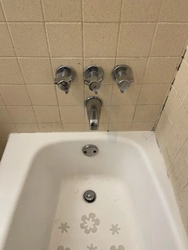 Tub and shower valve replacement, before: Old three-handle valve